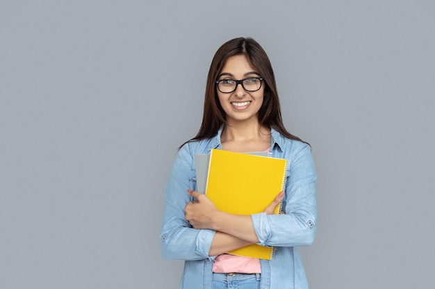 Estudiante india feliz sostiene libro cuaderno cuaderno de notas aislado espacio de copia