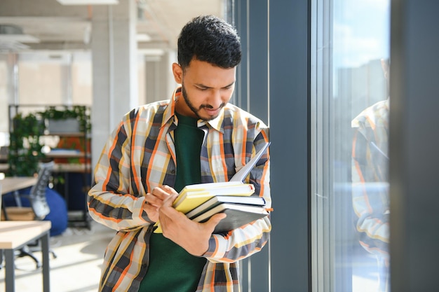 Estudiante indio con libros en la universidad