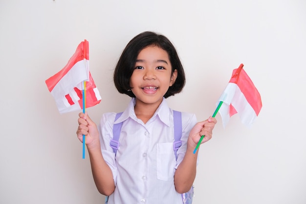 Estudiante indonesio mostrando expresión feliz al sostener la bandera de la nación