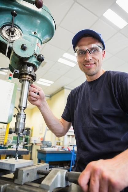 Estudiante de ingeniería usando taladro grande