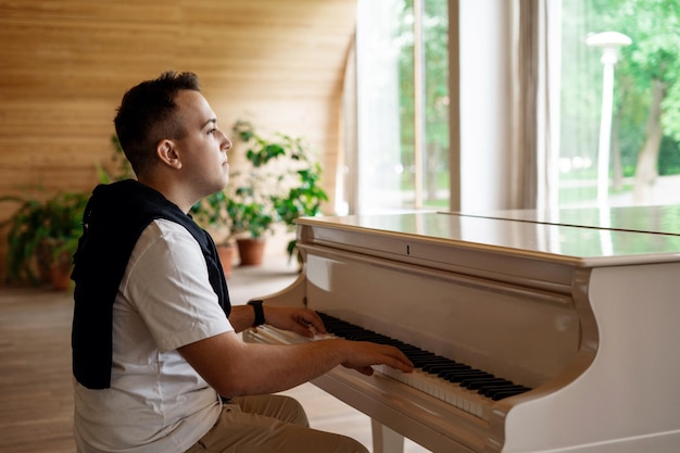 Un estudiante del instituto está sentado al piano estudiando partituras Aprendizaje a distancia en línea