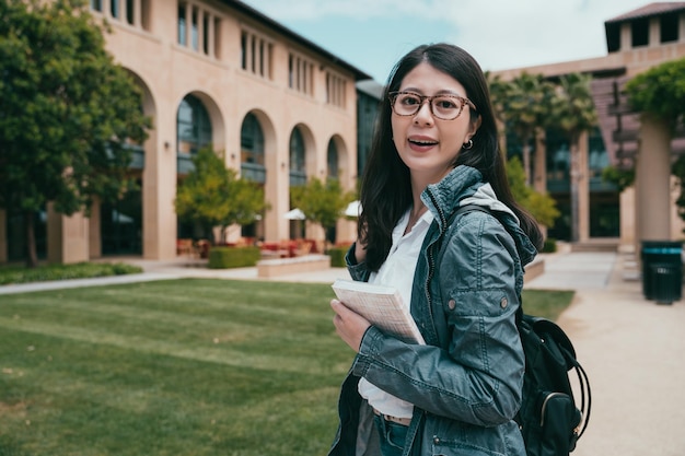 estudiante internacional femenina que se ve feliz y se dirige a su salón de clases.