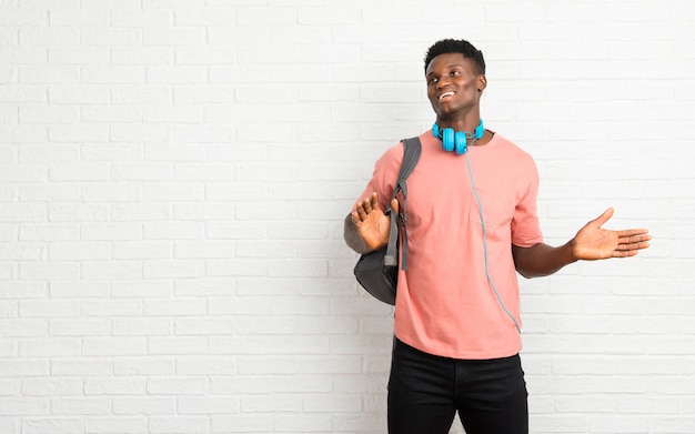 Estudiante joven del afroamericano que hace gesto sin importancia y de las dudas