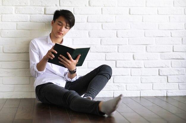 Estudiante joven asiático con libros en las manos