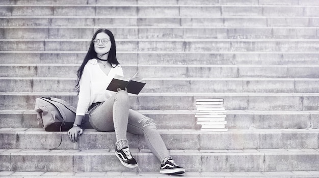 Estudiante joven en la calle con una mochila y libros