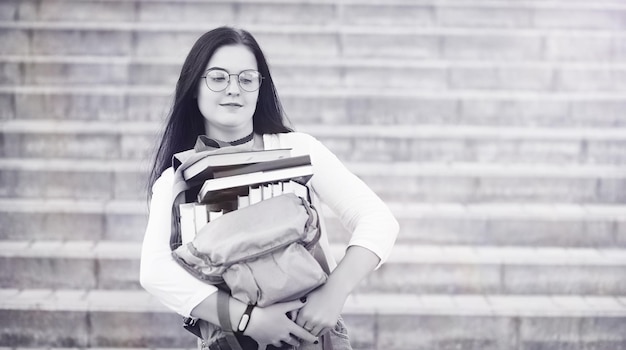 Estudiante joven en la calle con una mochila y libros