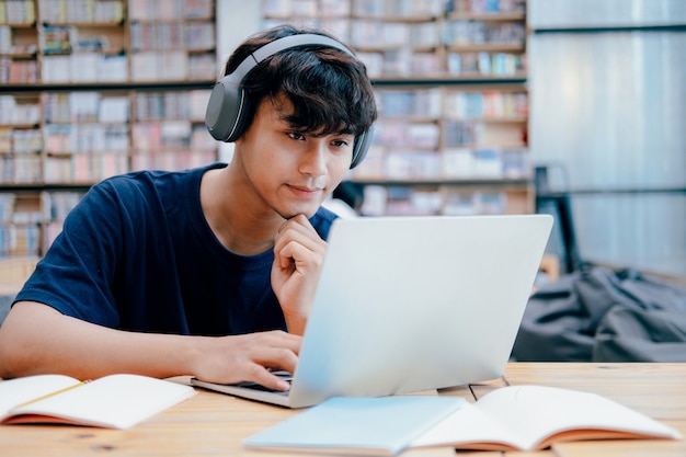 Estudiante joven del collage que usa la computadora y el dispositivo móvil que estudian en línea. Educación y aprendizaje en línea.