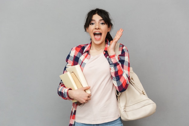 Estudiante joven feliz que se coloca aislado