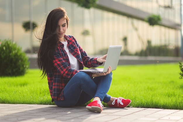 Estudiante joven morena trabajando al aire libre