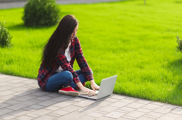 Estudiante joven morena trabajando al aire libre