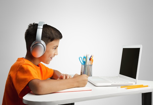 Estudiante joven o niño que asiste a la escuela en línea usando computadora estudiando usando una computadora portátil.