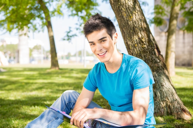 Foto estudiante joven que estudia en el jardín de la escuela