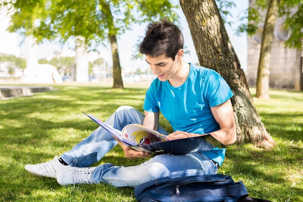 Estudiante joven que estudia en el jardín de la escuela