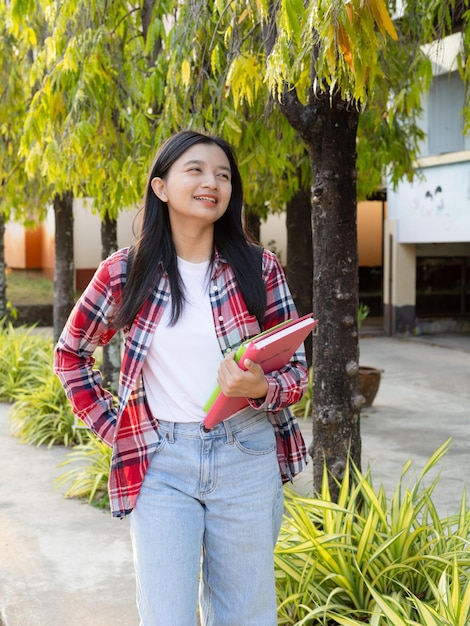 Estudiante joven sostiene pecho y caminando en la escuela