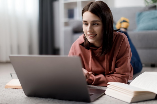 Foto estudiante con laptop en piso