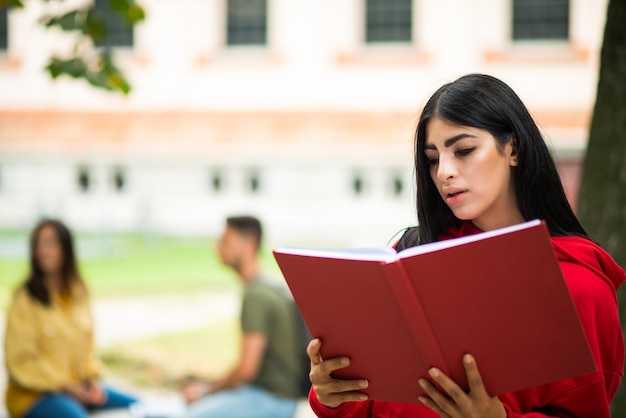 Estudiante leyendo un libro al aire libre