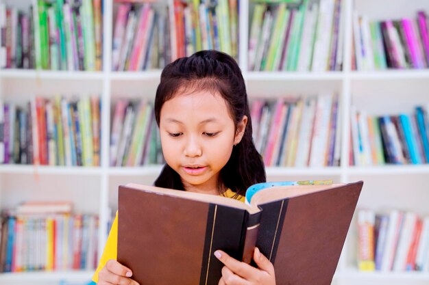 Estudiante leyendo un libro en la biblioteca