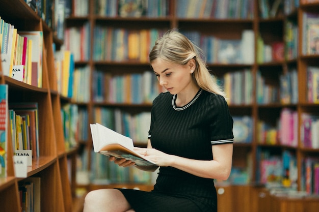 Estudiante leyendo un libro en la biblioteca