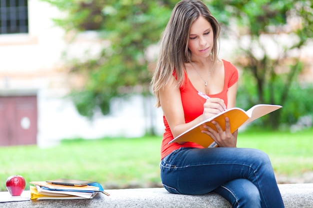 Estudiante leyendo un libro en el parque