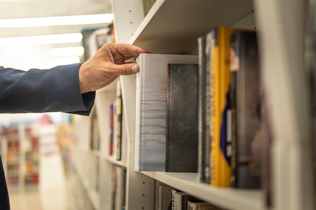 Estudiante en librería o biblioteca. el hombre elige literatura en una librería. Un empresario compra un libro como regalo.