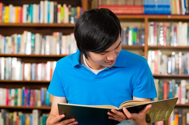 Estudiante en libro de lectura de la biblioteca