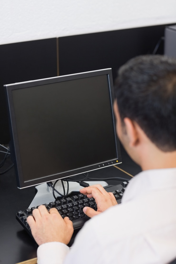 Foto estudiante maduro en sala de informática