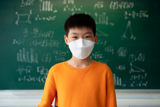 Foto estudiante con mascarilla médica en la escuela.