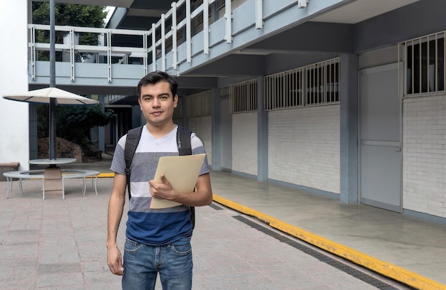 Foto un estudiante masculino en la universidad con un periódico en la mano