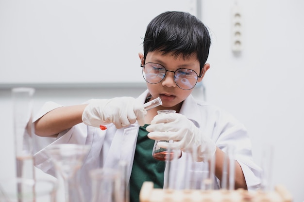 Estudiante de medicina de la escuela vertiendo líquido en la cristalería en el laboratorio Día Nacional de la Ciencia