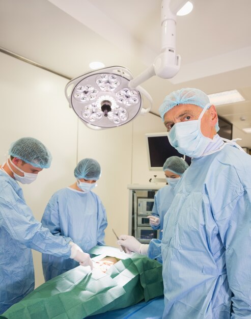 Estudiante de medicina mirando a la cámara durante la práctica de cirugía