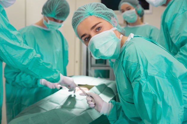 Estudiante de medicina mirando a la cámara durante la práctica de cirugía