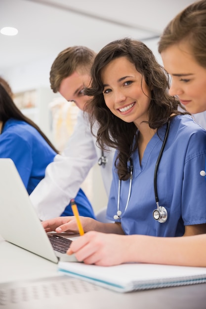 Foto estudiante de medicina sonriendo a la cámara durante la clase