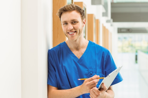Estudiante de medicina sonriendo a la cámara en el pasillo