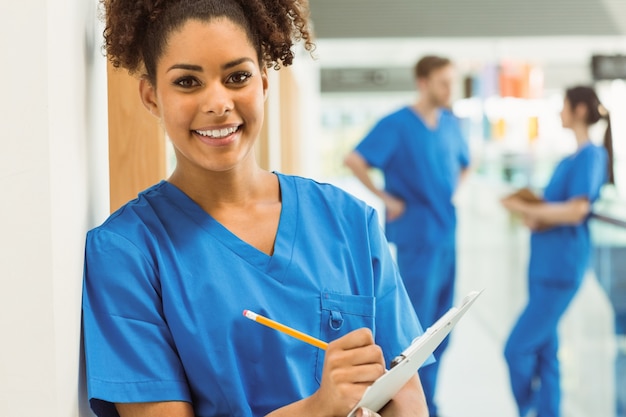 Estudiante de medicina tomando notas en el pasillo