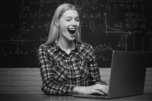 Estudiante mirando a la cámara alegre estudiante sonriente en el estudio de tutor universitario de pizarra