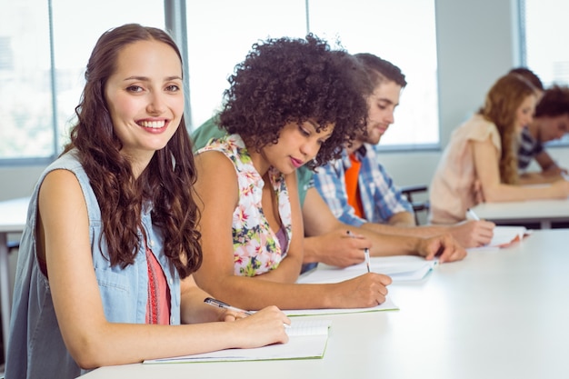 Estudiante de moda tomando notas en clase