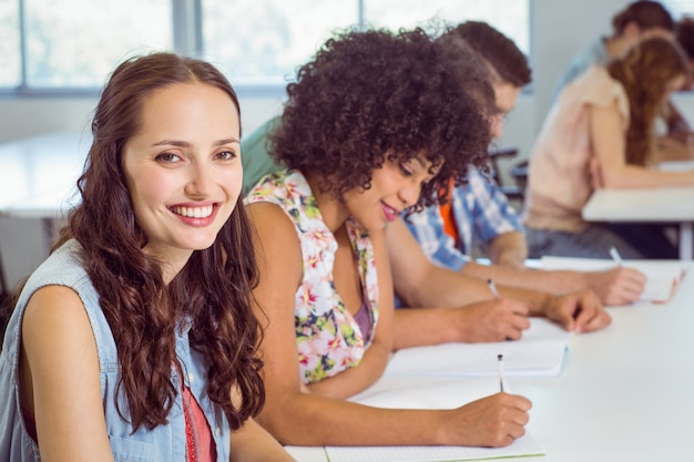 Estudiante de moda tomando notas en clase.