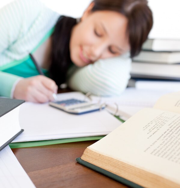 Foto estudiante morena haciendo su tarea en un escritorio