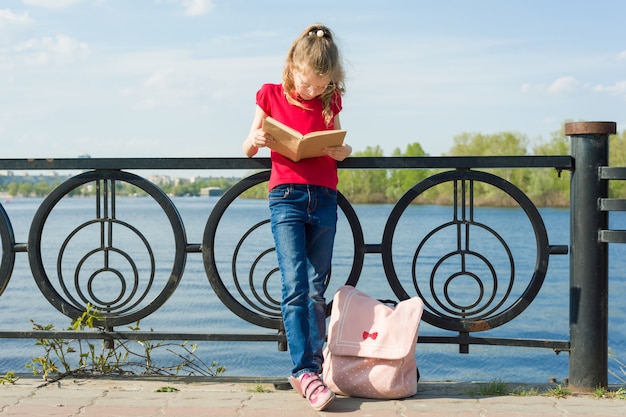 El estudiante de la muchacha del niño que lleva los vidrios con la mochila es libro de lectura