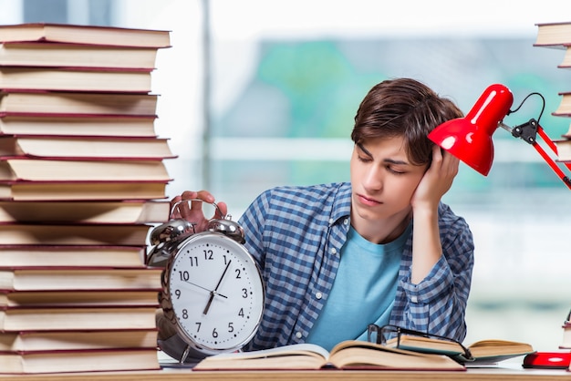 Estudiante con muchos libros preparándose para los exámenes.