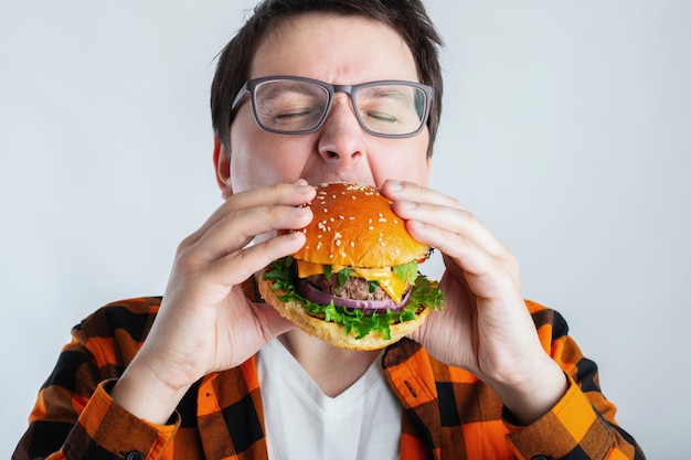 Un estudiante muy hambriento come comida rápida.