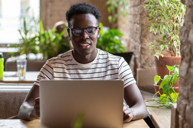 Estudiante negro viendo webinar educativo en portátil