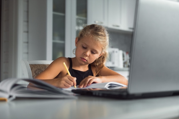 estudiante niña estudia en casa con laptop