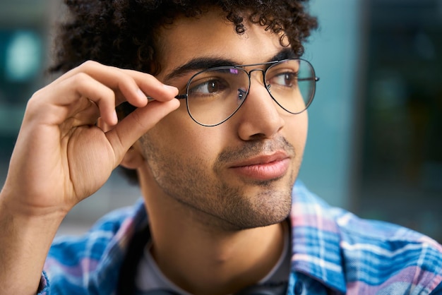 Estudiante de oriente medio guapo pensativo mirando a otro lado a través de gafas