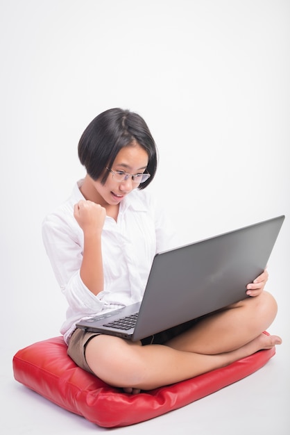 Estudiante pequeña tarea de colegiala en la computadora portátil