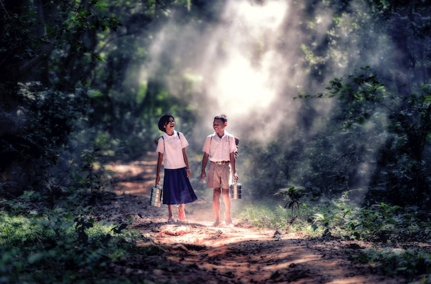 Estudiante pequeño muchacho y muchacha asiáticos, campo en Tailandia