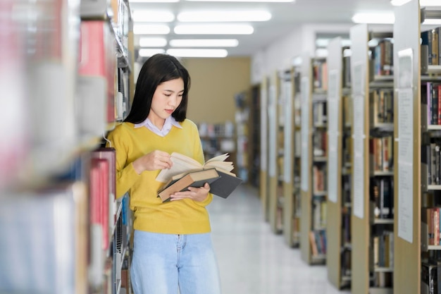 Estudiante de pie y leyendo un libro en la biblioteca