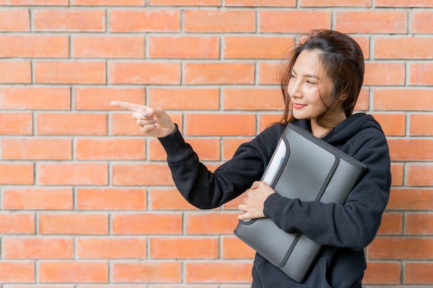 Estudiante de pie en la pared en el campus