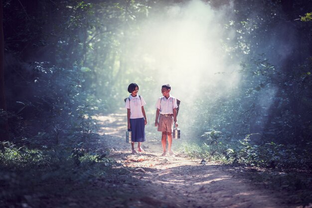 Estudiante poco asiático niño y niña, campo en Tailandia