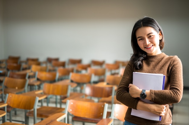 Estudiante posa en un aula universitaria